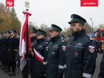 Kompania reprezentacyjna Izby Administracji Skarbowej w Poznaniu stoi w szeregu na baczność. Jeden z funkcjonariuszy trzyma sztandar.